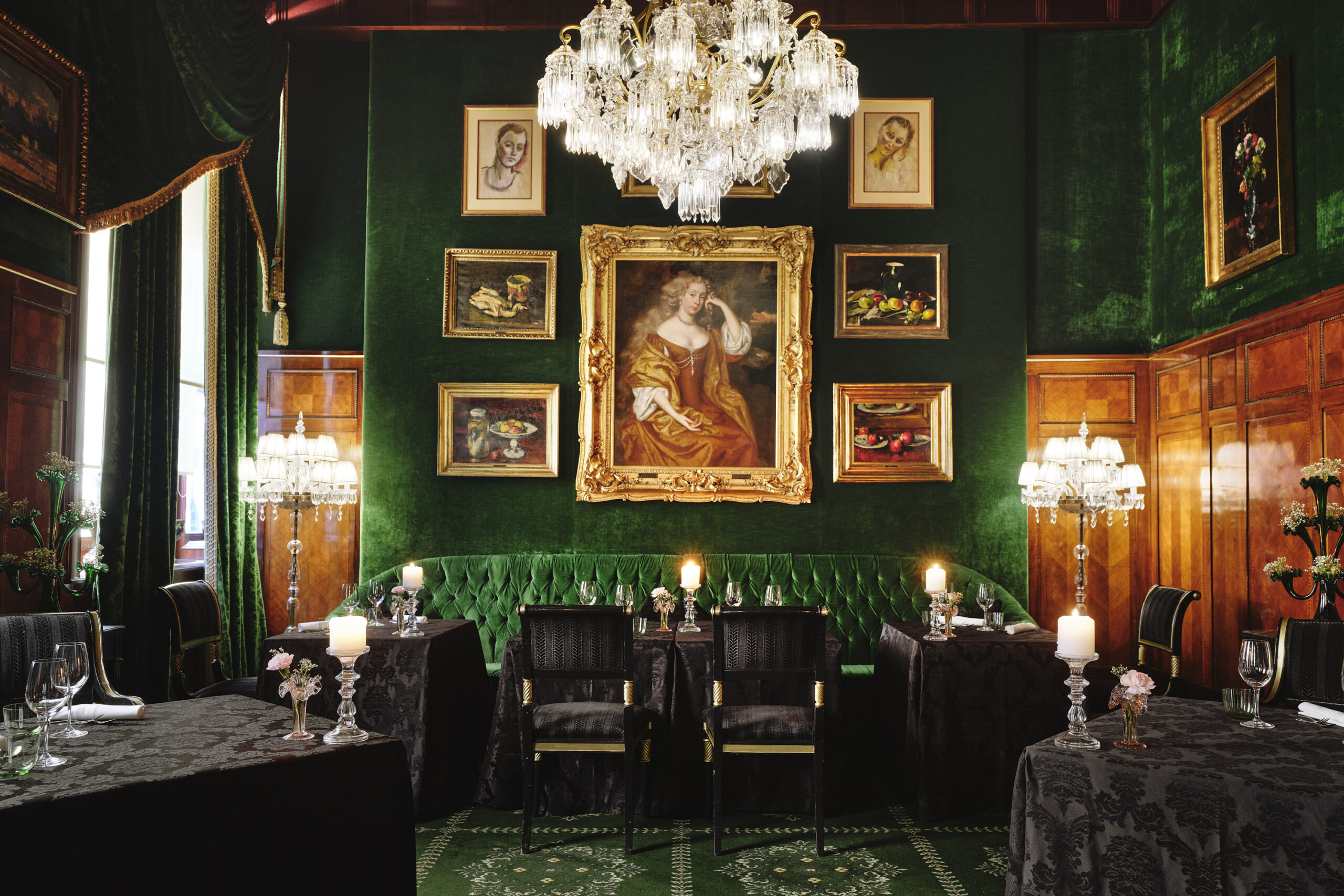 Opulenter Speisesaal mit gedeckten Tischen, weißen Stühlen, Marmorsäulen und glitzernden Kronleuchtern.