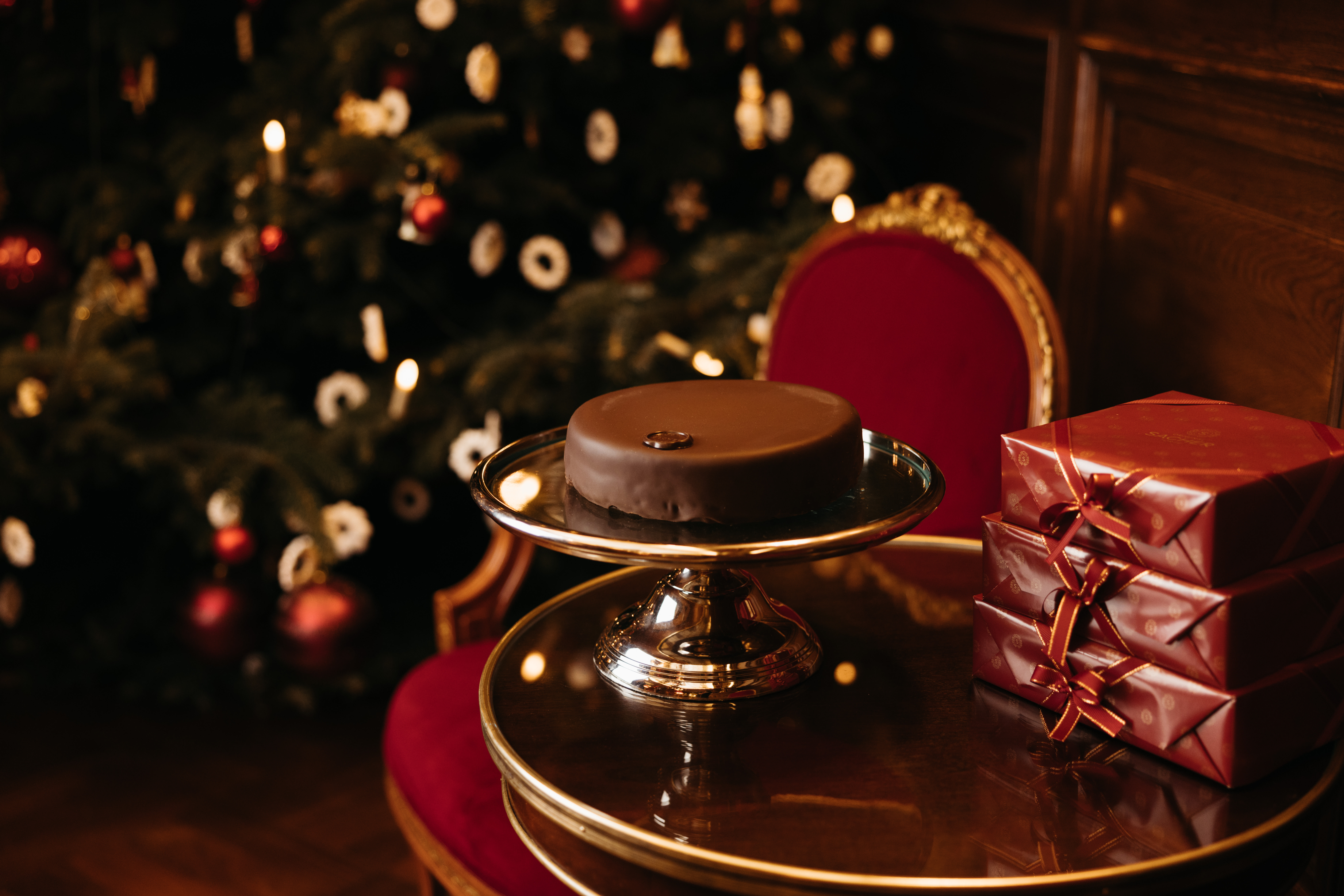 Opulenter Speisesaal mit gedeckten Tischen, weißen Stühlen, Marmorsäulen und glitzernden Kronleuchtern.