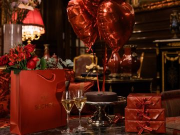 Romantic gift arrangement at Hotel Sacher featuring Sacher cake, champagne, red balloons and an elegant, festive setting