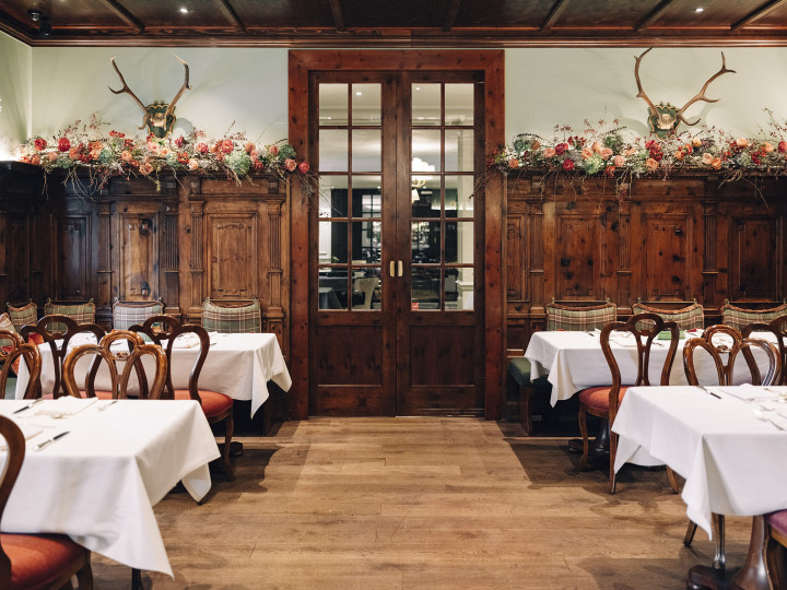 Elegant Zirbelzimmer at Hotel Sacher Salzburg with wood paneling and floral decorations.