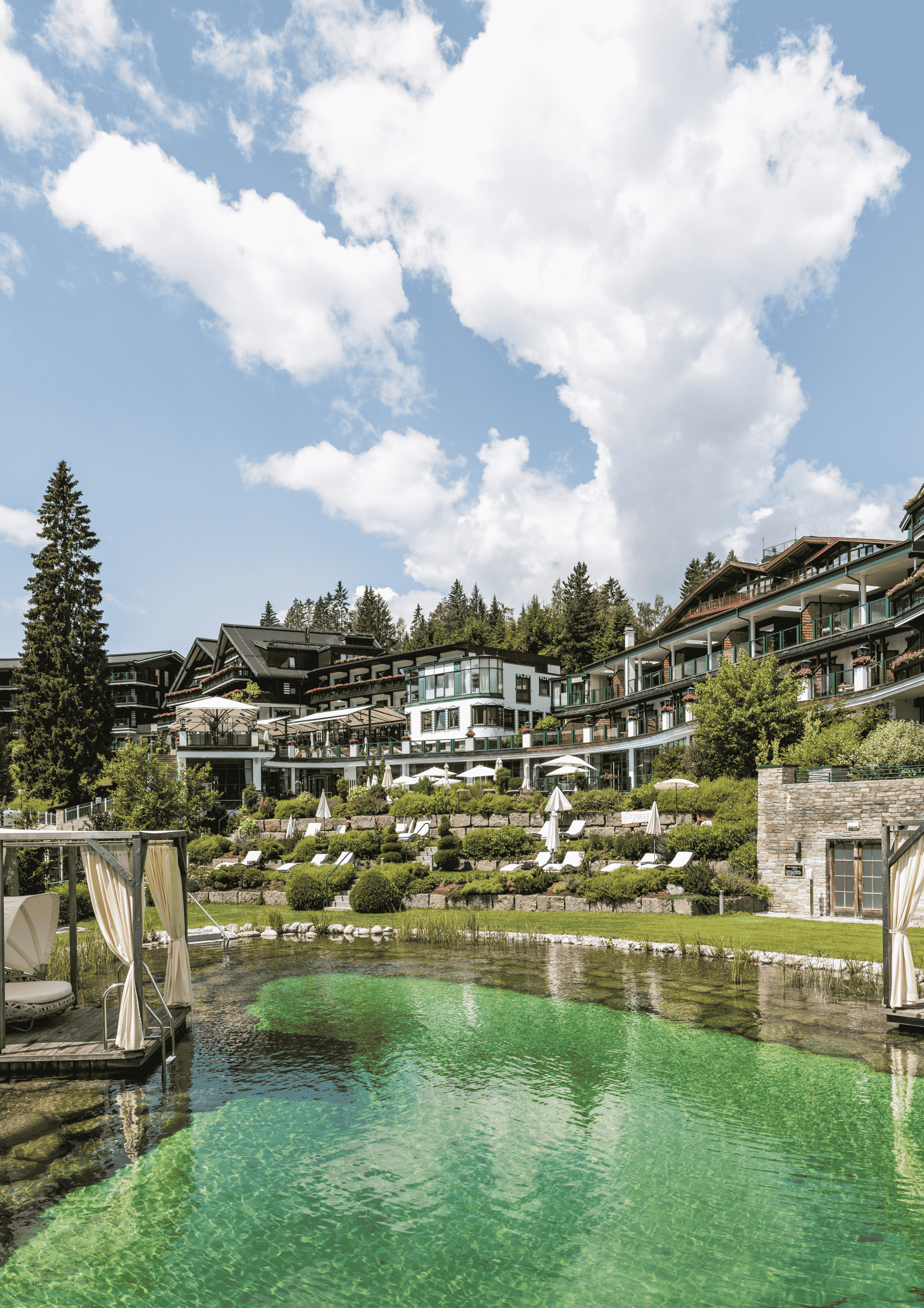 Luxuriöses Hotel mit gestuften, landschaftlich gestalteten Terrassen, einem natürlichen Badeteich und Cabanas am Wasser unter bl
